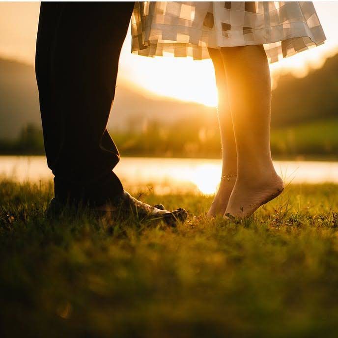 Eine Person in einem Steinlabyrinth am Meer steht nahe einer Felsenküste.